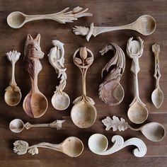 many spoons are arranged on a wooden surface with different shapes and sizes to choose from