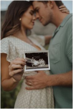 a pregnant couple holding an old photo in their hands