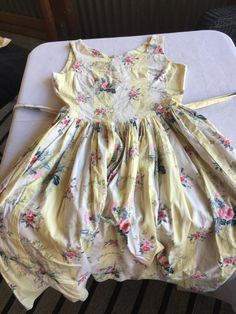 "Retro Cotton Gathered Sleeveless Sundress, gathered skirt with buttoned waist ties that tie in the back like an apron. Has a back zipper, and looks maybe handmade, as there's no tag or lining. (Very cool in the summer because there's no lining and it's pure cotton. VERY classic 50s summer dress, perfect for Easter parties or barbeques. It doesn't have a size tag, but I'd say it was a 10 based on the measurements. Laying flat, it looks like it's 35\" at the bust, 31\" at the waist, and huge at t Spring Dress With Gathered Waist And Full Skirt, Spring Dresses With Gathered Waist And Full Skirt, Sleeveless Dress With Gathered Skirt And Fitted Bodice, Spring Sleeveless Fitted Bodice Dress, Summer A-line Dress With Gathered Skirt, Cotton A-line Dress With Tie Back, Cotton Sleeveless Dresses For Dress Down, Sleeveless Cotton Dress For Casual Wear, Knee-length Tie-back Daywear Dress