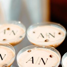 four glasses filled with drinks sitting on top of a table