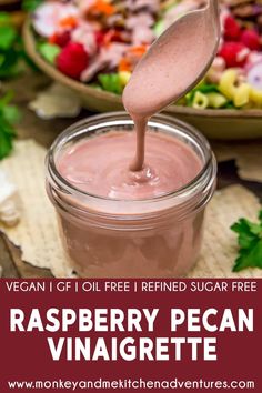 a spoon full of raspberry pecan vinaigrete is being poured into a jar