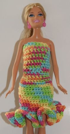 a crocheted doll is wearing a multicolored dress