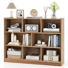 a book shelf filled with books next to a lamp and pictures on top of it