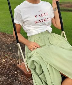 Master the art of casual elegance with this timeless Parisian outfit. A soft, graphic Paris t-shirt tucked into a flowy, long skirt creates the perfect blend of laid-back comfort and chic style. Add a pair of espadrilles or classic ballet flats for an easy, stylish look. Whether you're strolling down the Champs-Élysées or relaxing at a café, this outfit embodies the effortless grace of Parisian fashion.

#ParisianChic #LongSkirtStyle #EffortlessElegance #ParisOutfitInspo #GraphicTeeAndSkirt #FrenchFashion #CasualParisian #EverydayChic Chic T-shirt For Casual Gatherings In Summer, Chic T-shirt For Casual Summer Gatherings, Chic Cotton T-shirt For Day Out, Flowy Long Skirt, Paris Market, Parisian Outfit, Paris Markets, Champs Élysées, T Shirt Outfit