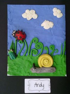 a paper plate with a snail, grass and clouds on it that says andy in the middle