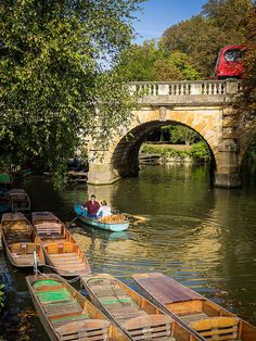 several small boats in the water near a bridge