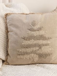 a pillow with a christmas tree embroidered on it