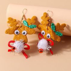 two reindeer earrings with red bows on them