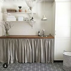 a kitchen area with a sink, counter and shelves on the wall next to it