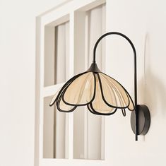 a light fixture hanging from the side of a white wall next to a door and window