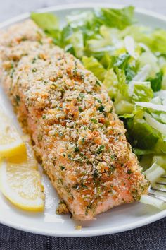 a white plate topped with fish and salad