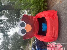 an inflatable toy car is parked on the side of the road next to a tree