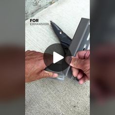 a person cutting something with a pair of scissors on top of carpeted flooring