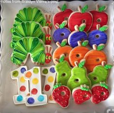 some very pretty decorated cookies in the shape of fruits and vegetables on a white plate