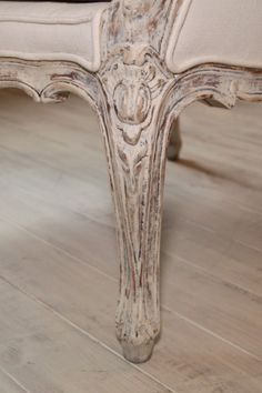 an old white bench sitting on top of a hard wood floor