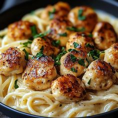 pasta with scallops and parsley in a black bowl