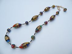 Klimt Style, Millefiori Murano Glass, Venetian Bead Necklace, with Gold Foil Beads, Adjustable Length 18 1/2 to 20 1/2 Inches, with Gold Filled Clasp and link chain. These beads are beautiful, detailed, handmade beads, made one-by-one in Venice, Italy. I had the Klimt style, Millefiori oval beads made with a topaz colored Murano glass base color; with 24 karat gold foil; and abstract patterns of multicolored mosaic, millefiori. The 12mm rounds are handmade with a base color of black Murano glass Elegant Multicolor Oval Beads Necklace, Elegant Multicolor Beaded Necklaces With Spacer Beads, Elegant Multicolor Necklace With Polished Beads, Elegant Multicolor Polished Beads Necklace, Formal Multicolor Polished Bead Necklaces, Formal Multicolor Polished Beads Necklace, Chain Messages, 24 Karat Gold, Topaz Color