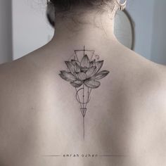 the back of a woman's shoulder with a lotus tattoo on it