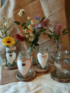 four mason jars with hearts and flowers in them