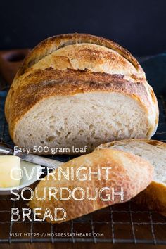 a loaf of overnight sourdough bread on a cooling rack with butter next to it