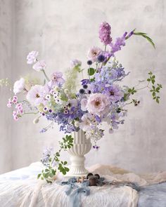 a vase filled with lots of purple and white flowers