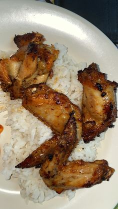 chicken and rice on a white plate with sauce