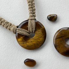 Donut gemstone design can be warn as necklace or choker! This shimmery tiger eye donut stone is quite large at 40mm wide and about 6mm thick (photos show front and back). The hemp chain is braided in a square knot style and is about 18 inches long (can be shortened to a choker length on request). Attaches in the back with a wooden bead through knotted loop. Handmade Cord Spiritual Jewelry, Spiritual Cord Jewelry For Gifts, Handmade Brown Cord Jewelry, Handmade Cord Jewelry Gift, Adjustable Amber Crystal Necklaces, Adjustable Amber Crystal Necklace Round, Adjustable Round Amber Crystal Necklace, Adjustable Amber Crystal Necklace, Hemp Necklace