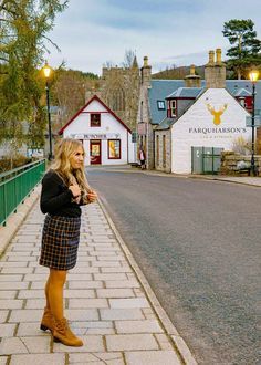 a woman standing on the side of a road