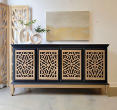 a sideboard with laser cutouts on the doors and drawers in front of it