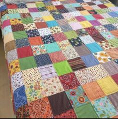 a bed with a colorful quilt on top of it