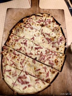 a sliced pizza sitting on top of a wooden cutting board