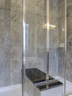 a walk in shower sitting next to a bathtub with a glass door and tiled walls