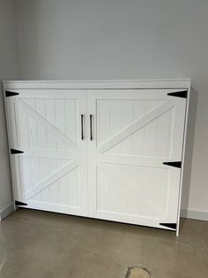 a large white garage door with black trim on the sides and bottom panel, in an empty room