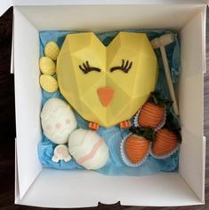 an origami chicken in a box with carrots and marshmallows