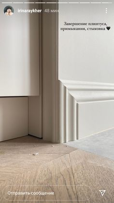 the corner of a room with white walls and wood flooring is seen in this image