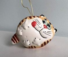 a ceramic cat ornament hanging on a wall