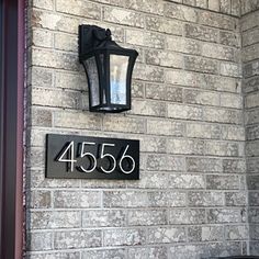 a brick building with a sign on it that reads 456 and has a lamp attached to the wall