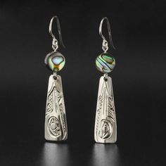 This listing is for one pair of hand-engraved sterling earrings by First Nations artist Carrie Matilpi. The price includes the shipping fee, except for shipments that must be sent overseas. Each pair is hand-engraved and will differ slightly from the images included here. Each pair measures 1.25" long by 0.5" wide and there are two options to choose from:Hummingbird with Abalone - symbol of joy and good luckWolf with Moonstone - symbol of family and communicationPlease allow 2-3 weeks for delive Polished Sterling Silver Earrings, Engraved Sterling Silver Dangle Jewelry, Unique Polished Drop Earrings, Engraved Teardrop Earrings For Gift, Polished Sterling Silver Earrings As A Gift, Engraved Sterling Silver Drop Earrings, Silver Engraved Round Earrings, Artisan Long Drop Pierced Jewelry, Artisan Teardrop Engraved Jewelry