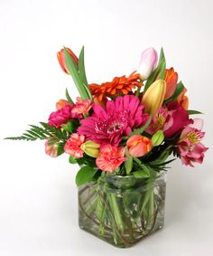 a vase filled with lots of colorful flowers