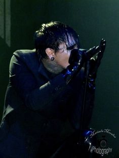 a man with black hair and piercings on stage