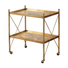 an antique brass serving cart with glass shelves