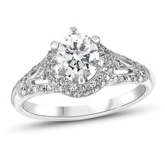 a white gold engagement ring with diamonds on the sides and an intricate band around it