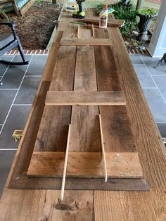 a long wooden table sitting on top of a tiled floor