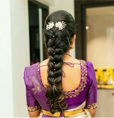 a woman with long hair wearing a purple sari and flowered headpiece in her hair