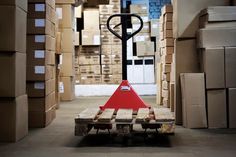 a forklift in a warehouse with boxes on the floor and a light pole behind it