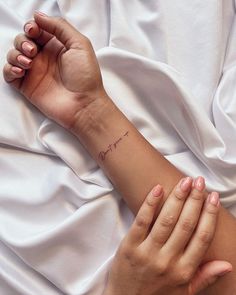 a woman's arm with a small tattoo on it