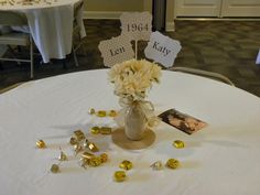 a vase filled with flowers sitting on top of a white table cloth covered round table