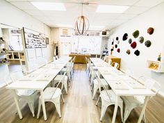 an empty room with white tables and chairs