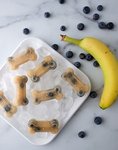 bananas and blueberries on ice with dog bone shaped candies in the shape of bones