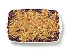 blueberry crisp in a white dish with crumbled topping